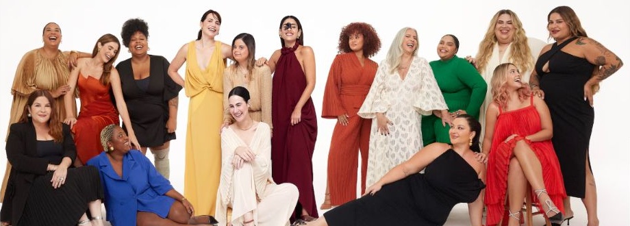 Dove Real Beauty Pledge group portrait: women of varied skin tones, body sizes, hair and ages laughing together in a white studio
